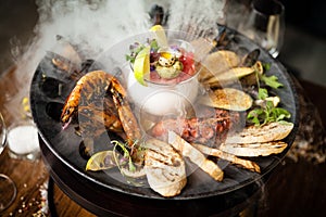 Seafood platter for 2-4 persons. Octopus, blue mussels, cooked green mussels, grilled tiger prawns, tuna tartare