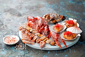 Seafood platter. Assorted seafood - smoked prawns and mussels on skewers, crayfish, fried scallops with red caviar, shell