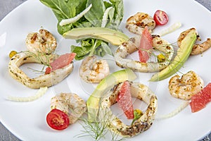 Seafood platter with deep fried squid rings, shrimp decorated with lemon on fresh arugula. Mediterranean appetizers. Top view