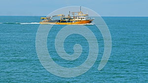 Seafood Production In The Sea Or Ocean. Fishing Boat Sails In The Open Sea. Real time. photo