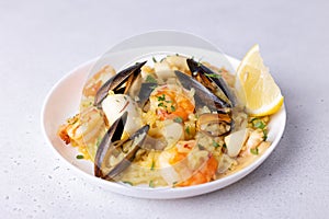 Seafood risotto with saffron, parsley and lemon. Arborio rice with tiger prawns, mussels and squid. Traditional Italian dish.