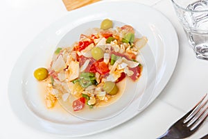 Seafood salad from slices of cod and vegetables
