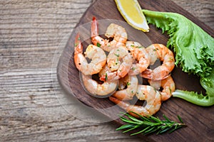 Seafood shelfish with rosemary lemon and lettuce - Salad shrimp grilled delicious seasoning spices on wooden cutting board