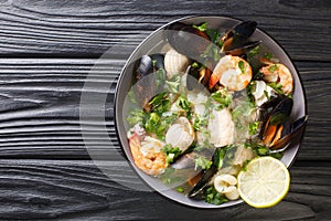 Seafood shellfish soup of mussels, Shrimps, clams and other shellfish typical chilean dish Paila marina or Mariscal close-up in a