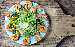 Seafood shrimp lettuce salad on blue plate
