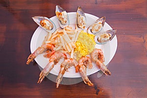 Seafood shrimps mussels dish with French fries and rice