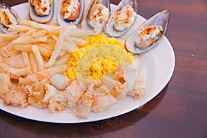 Seafood shrimps mussels dish with French fries and rice