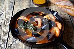 Seafood soup bouillabaisse. Mussels and shrimp in tomato sauce. The traditional dish of Marseilles. Rustic style.