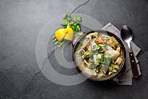 Seafood Soup in clay bowl on gray slate background
