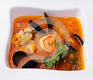 Seafood soup in white bowl top view