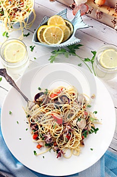 Seafood Spaghetti on a White Table with Glasses of Lemon Water