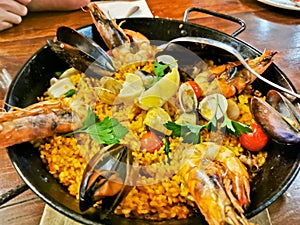 Seafood Spanish Paella with black lips mussels and tiger prawns served in black pan