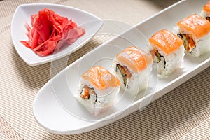 Seafood sushi rolls in white plate with chopsticks and japanese spices