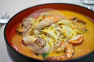 seafood tagliatelle with shrimp, lobster claw, scallops and butter sauce in a plate at the restaurant