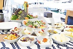 Seafoods, fish, salad and mezes on the table near the sea