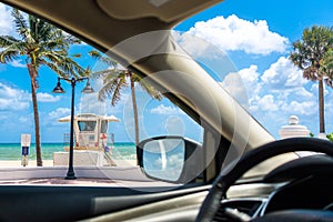 Seafront beach promenade with palm trees on background on sunny day in Fort Lauderdale in Florida USA, view from a car