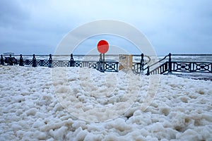 Seafront promenade in a storm, foam from the sea all over the pr