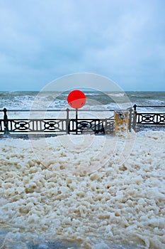 Seafront promenade in a storm, foam from the sea all over the pr