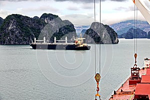 Seagoing vessels, barges, tugboats and small boats at the roadstead of Halong bay under cargo operations and underway. Port of Cam