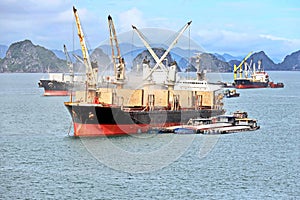 Seagoing vessels, barges, tugboats and small boats at the roadstead of Halong bay under cargo operations and underway. Port of Cam