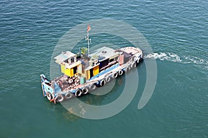 Seagoing vessels, barges, tugboats and small boats at the roadstead of Halong bay under cargo operations and underway. Port of Cam