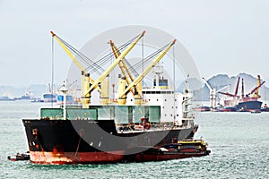 Seagoing vessels, barges, tugboats and small boats at the roadstead of Halong bay under cargo operations and underway. Port of Cam