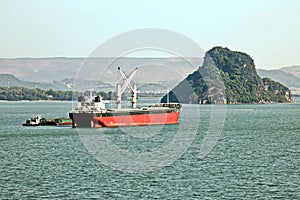 Seagoing vessels, barges, tugboats and small boats at the roadstead of Halong bay under cargo operations and underway. Port of Cam