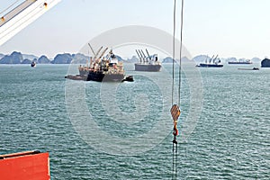 Seagoing vessels, barges, tugboats and small boats at the roadstead of Halong bay under cargo operations and underway. Port of Cam
