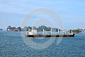 Seagoing vessels, barges, tugboats and small boats at the roadstead of Halong bay under cargo operations and underway. Port of Cam