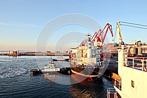 Seagoing vessels, tugboats at the port under cargo operations and underway in the port of Huludao, China, November, 2020.