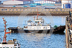 Seagoing vessels, tugboats at the port under cargo operations and underway in the port of Huludao, China, November, 2020.