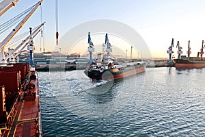 Seagoing vessels, tugboats at the port under cargo operations and underway in the port of Huludao, China, November, 2020.