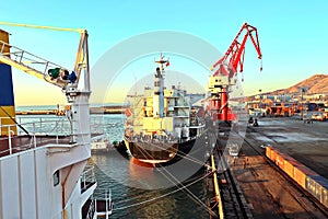 Seagoing vessels, tugboats at the port under cargo operations and underway in the port of Huludao, China, November, 2020.