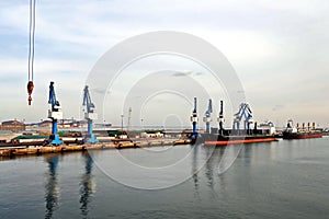 Seagoing vessels, tugboats at the port under cargo operations and underway in the port of Huludao, China, November, 2020.