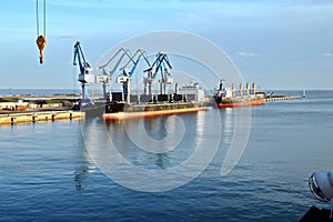 Seagoing vessels, tugboats at the port under cargo operations and underway in the port of Huludao, China, November, 2020.