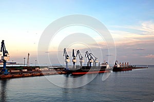 Seagoing vessels, tugboats at the port under cargo operations and underway in the port of Huludao, China, November, 2020.