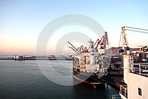 Seagoing vessels, tugboats at the port under cargo operations and underway in the port of Huludao, China, November, 2020.