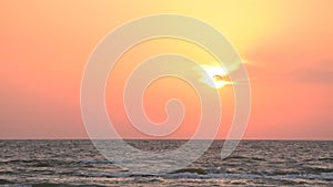 Seagull flies on background of rising sun over sea