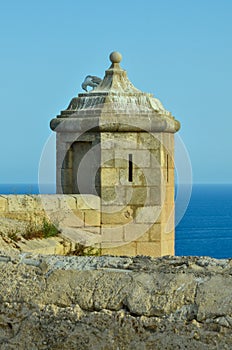 A seagull sits on a castle tower of castillo de Santa BÃ¡rbara in Alicante overlooking the Mediterranean Sea