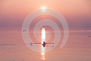 Seagulls Flying over Rowing Team Trainer over Shimmering Lake at Sunset