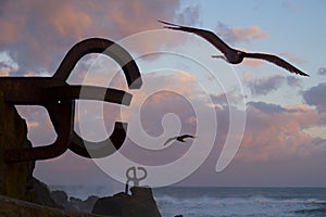 Seagulls and sculpture `Peine del Viento` in San Sebastian photo