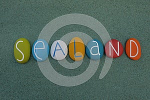 Sealand, souvenir with multicolored stone letters over green sand