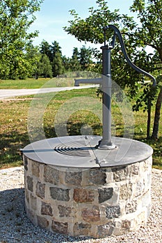 Sealed wells with hand pump in an orchard photo