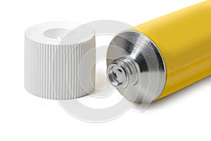 Sealed yellow tube of ointment and cap on a white background. Full depth of field