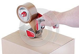 Sealing a shipping cardboard box with adhesive tape dispenser