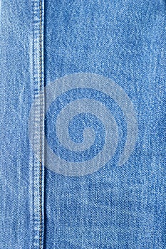 Seam on blue jeans background.