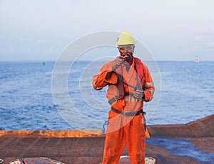 Seaman AB or Bosun on deck of offshore vessel or ship , wearing PPE