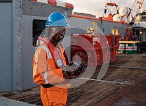 Seaman AB or Bosun on deck of offshore vessel or ship , wearing PPE