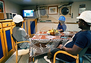 Seamen crew onboard a ship or vessel having fun watching TV