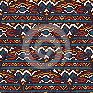 Seamless african pattern. Ethnic and tribal motifs. Orange, red, yellow, blue and black colors. Grunge texture. Vintage print for